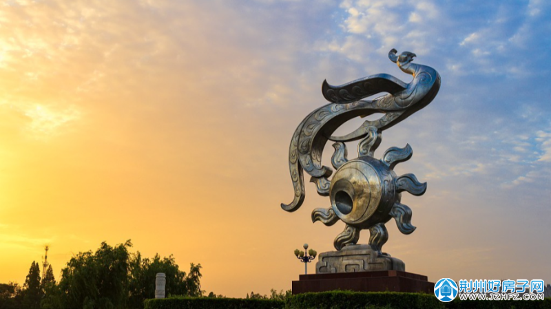 九龙桥为大背景以图腾柱雕塑为主题展示楚文化金凤腾飞在蓝天白云以及